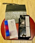 黒い紙袋、パンフ、ケーキのセット